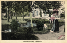 14653 Afbeelding van een boerin tijdens het voeren van een geit op een boerenerf te Tienhoven; met op de achtergrond de ...